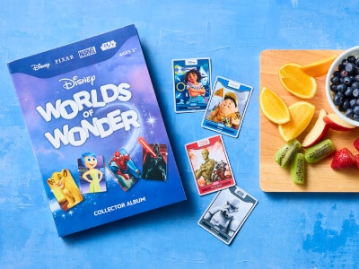 Disney Worlds of Wonder collector album alongside a fruit platter.