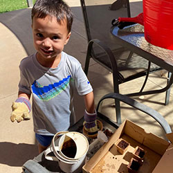 Child planting Discovery Garden plants